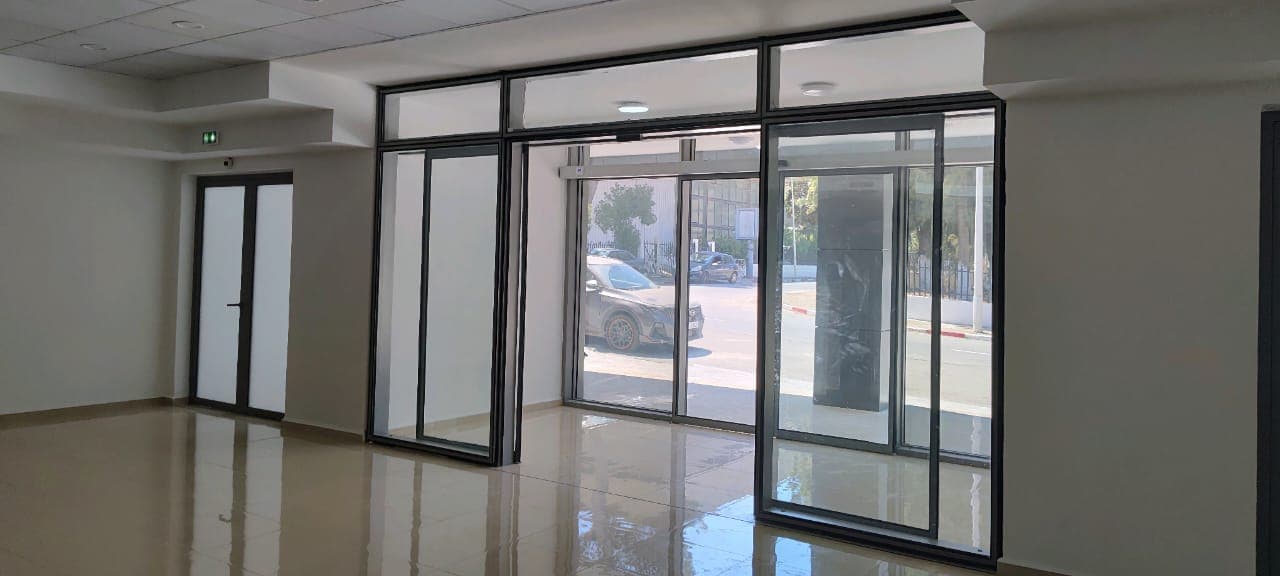 Porte automatique coulissante ouverte, aluminium noir et verre