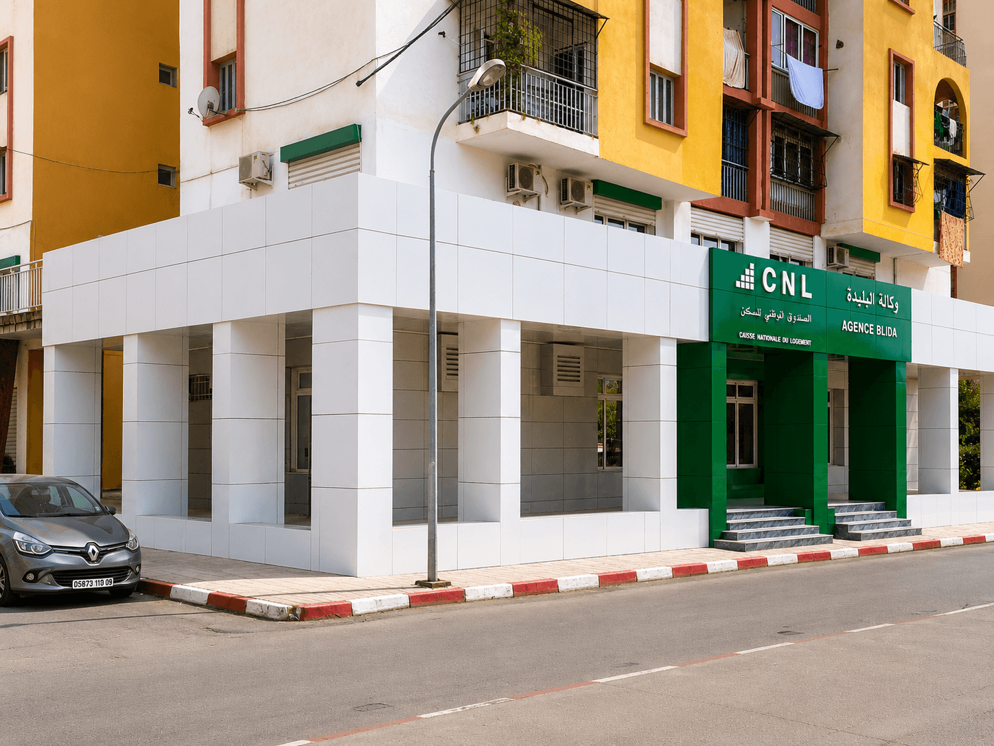 Habillage de façade ALUCOBOND blanc sur zone commerciale en rez-de-chaussée d'un immeuble résidentiel