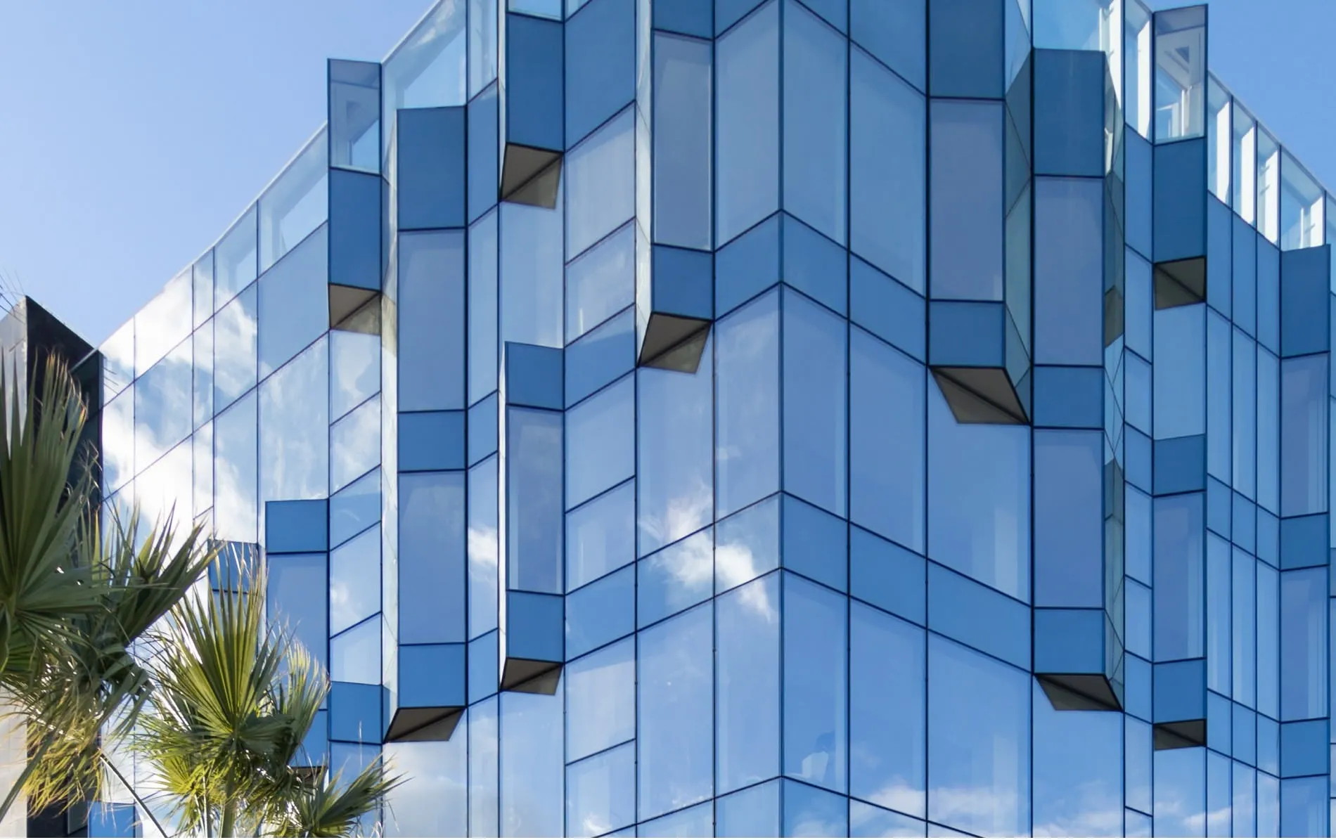 Mur-rideau en verre bleu à facettes sur façade architecturale moderne